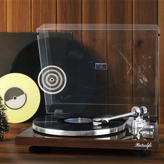 Retro turntable with vinyl record on wooden table, clear dust cover, and vintage decor