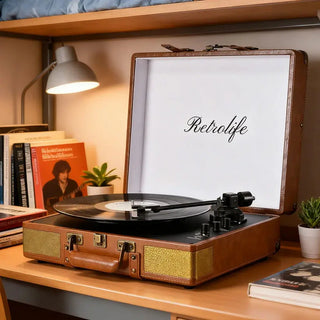 Retrolife suitcase record player on dorm desk with books, lamp, and potted plants