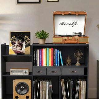 Suitcase record player with Bluetooth on a black shelf, vinyl records, books, and decor