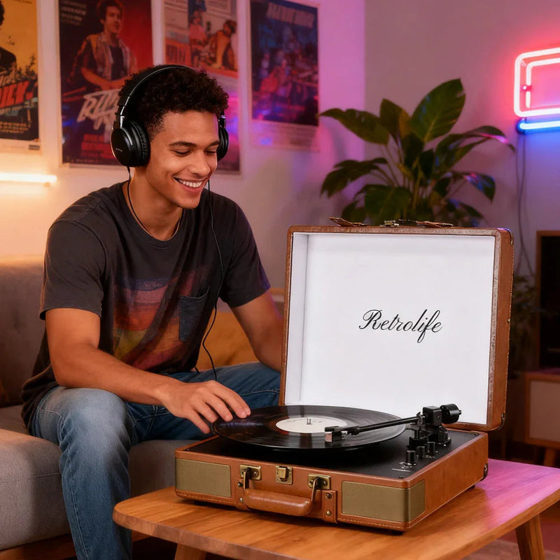 Man listening to vinyl on Retrolife R601 record player in cozy living room with posters