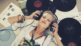 Woman with headphones relaxing among vinyl records and music sheets
