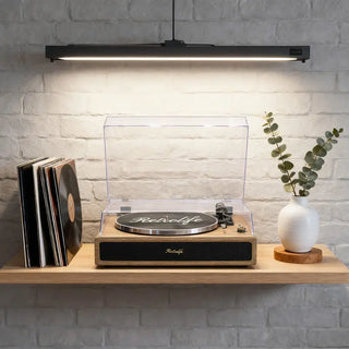 Retro-style all-in-one record player on wooden shelf with vinyl records and vase