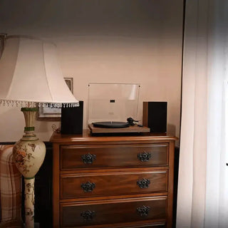 Bluetooth record player HiFi system on wooden dresser with speakers and vintage lamp