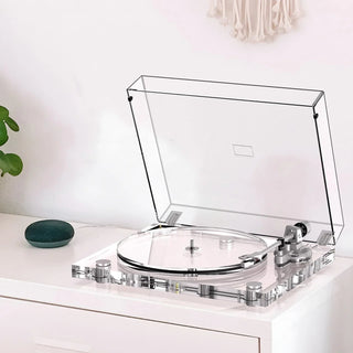 Clear acrylic high fidelity turntable with dust cover on white cabinet, modern decor