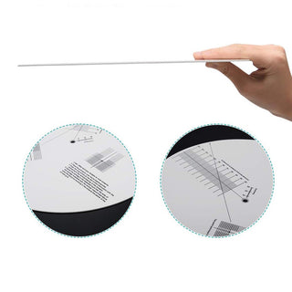 Acrylic turntable cartridge alignment protractor mat with printed grid, held by a hand.